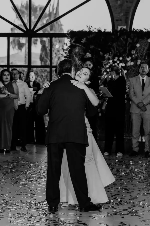 Abrazo emotivo durante la recepción en blanco y negro
